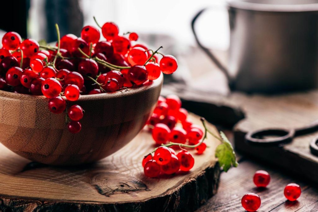 Fresh red currents in a wood bowl