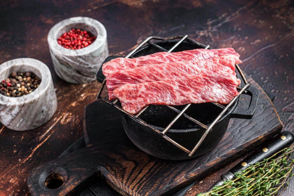 Premium raw sliced grass bed wagyu on a grill