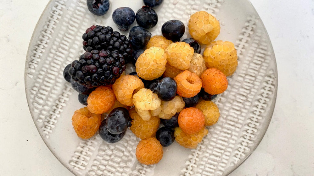 Fresh yellow pink raspberries with blackberries and blueberries