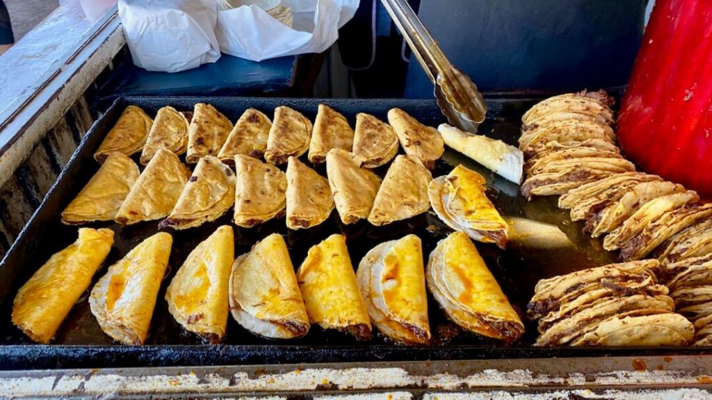 Juicy lamb birria tacos street food being grilled at Birrieria El Valle in Loreto, Mexico