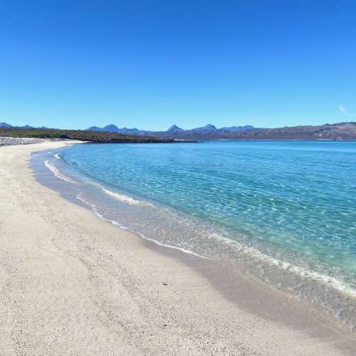 A pristine white sand beach and crystal clean turquoise calm waters at Isla Coroado, Loreto