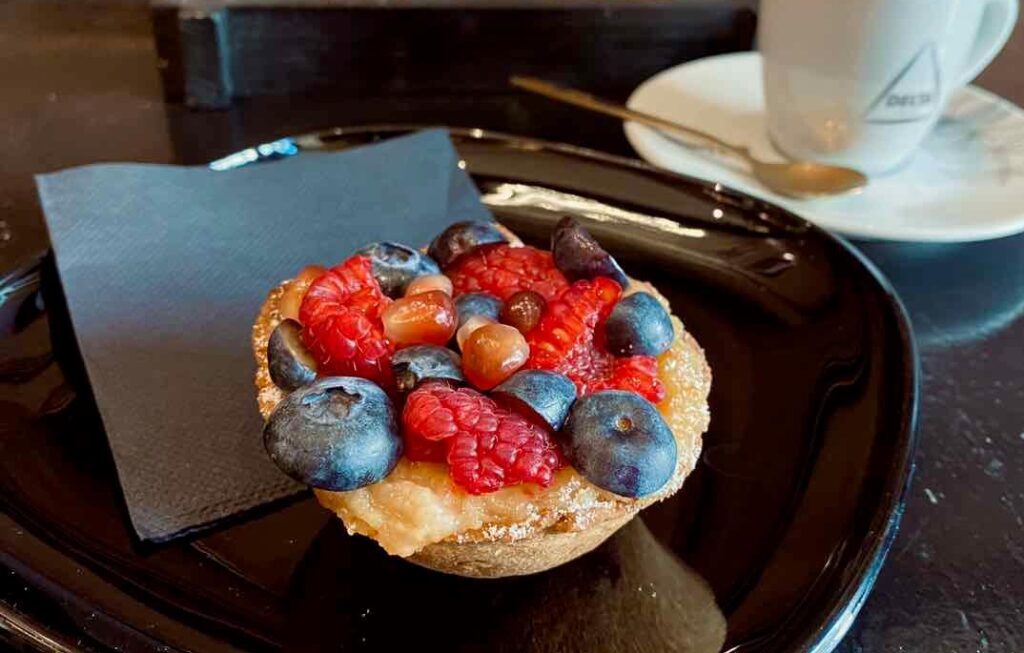 Lisbon bakery Bolo dOro fruit tart with berries and pomegranate and coffee