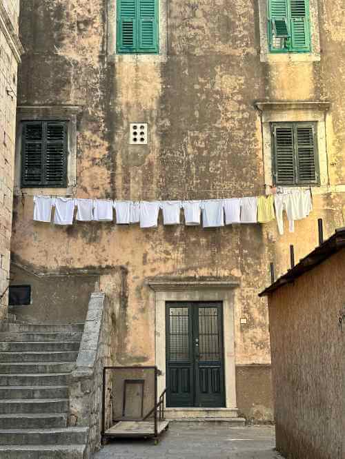 A line of hanging white t-shirts outside the house in Dubrovnik Old Town, Croatia