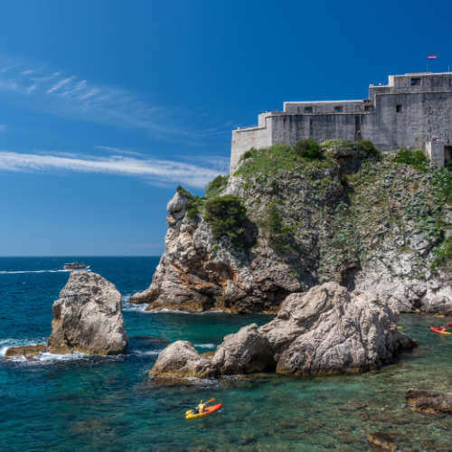 Sea kayakers kayaking around Dubrovnik Old town, next to Fort Lawrence (Lovrijenac) in Croatia