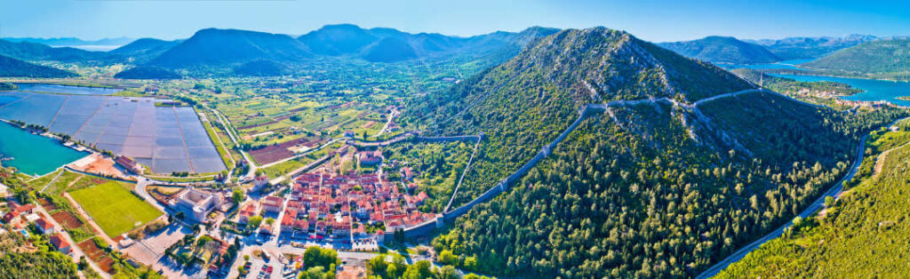 Panoramic aerial view of Ston, the long Ston walls along the mountains, the saltworks (fields) and rivers in Croatia