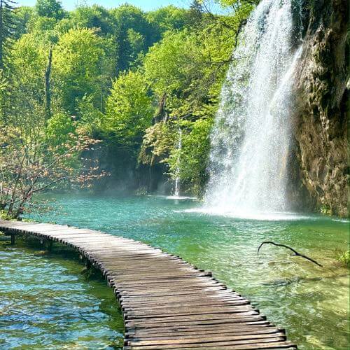 A view of boardwalk on the lake right next to waterfalls in Lower Lakes, Plitvice Lakes National Park, Croatia