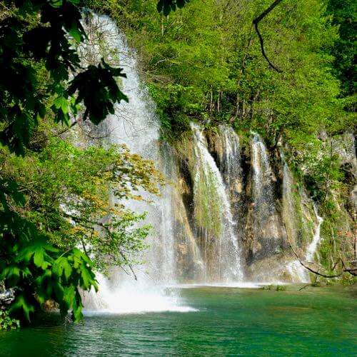 Multiple waterfalls falling into the lake in Plitvice Lakes National Park, Croatia
