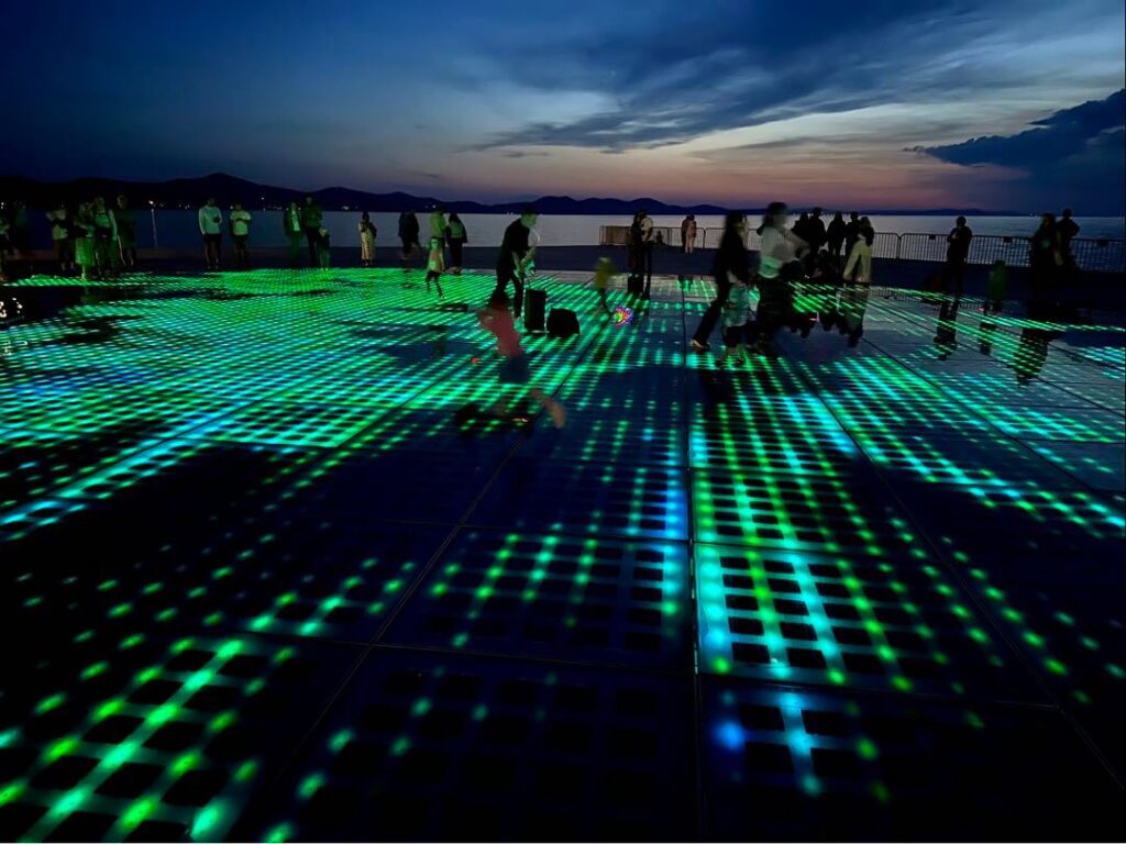 People enjoying the live music and light show of the Monument to the Sun/Greeting to the Sun in Zadar, Croatia